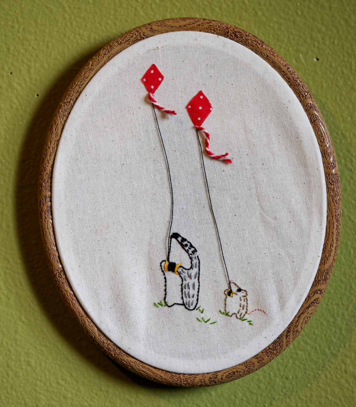 embroidered badger and mouse flying kites, hanging on wall
